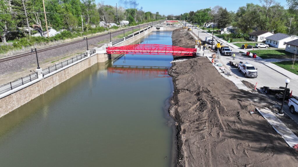 Image of red pedestrian bridge in Garden Hills neighborhood, Champaign, IL, over new detention basin.