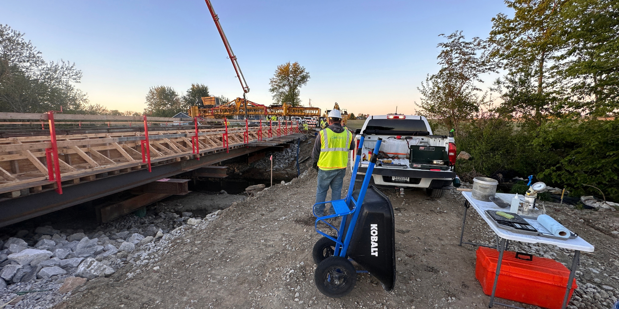 Inspection and Materials Testing A Clark Dietz inspector stands beside Bridge No. 109 construction, with concrete testing equipment on a nearby table and deck forms spanning Ramp Run.
