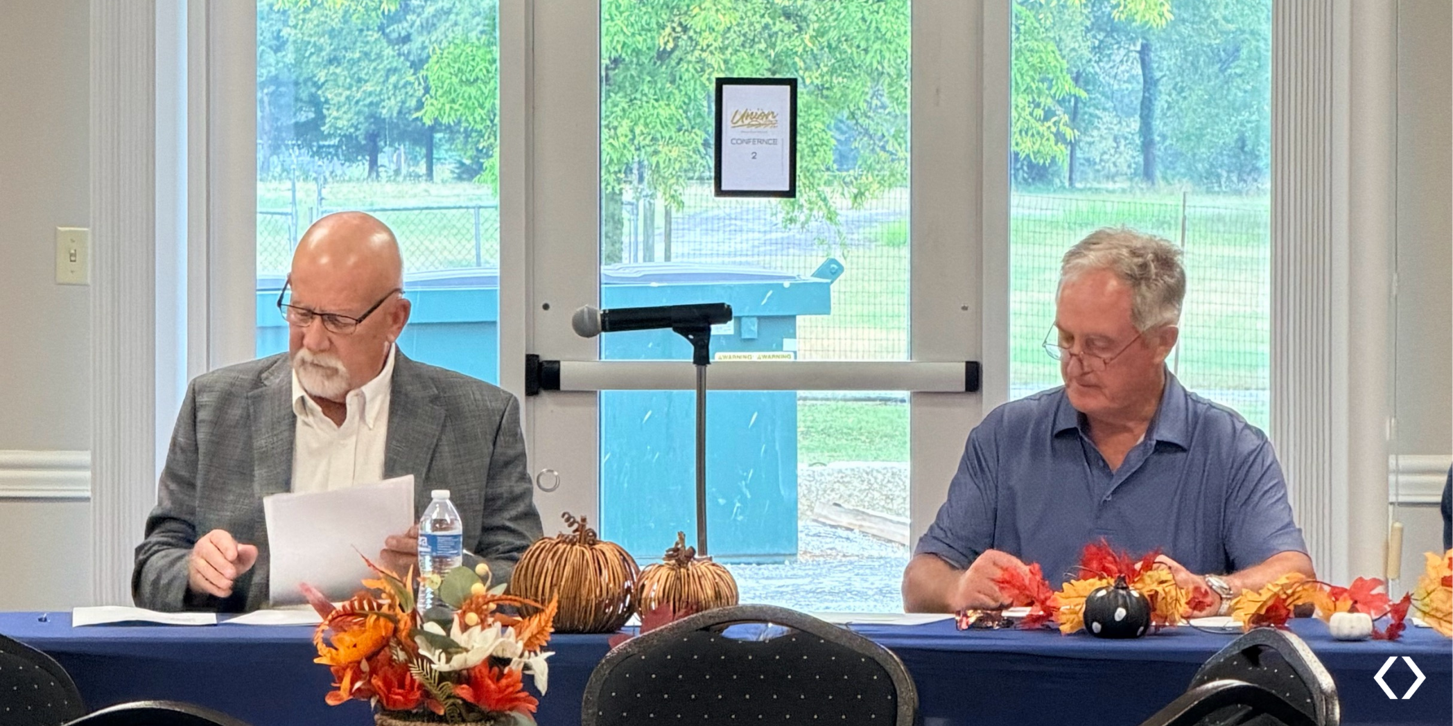 Sturgis Mayor Billy Adams and Councilman Hunter Adams seated at a meeting table reviewing documents.
